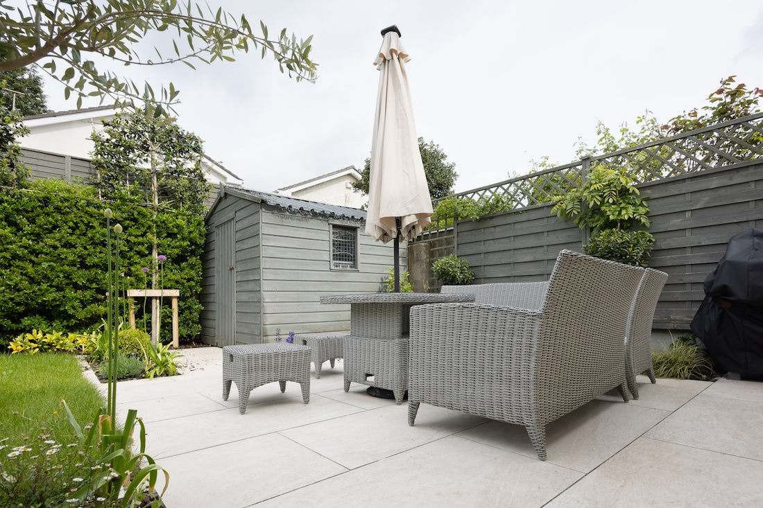 A patio with a table and chairs and an umbrella