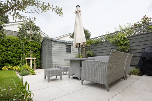 A patio with a table and chairs and an umbrella