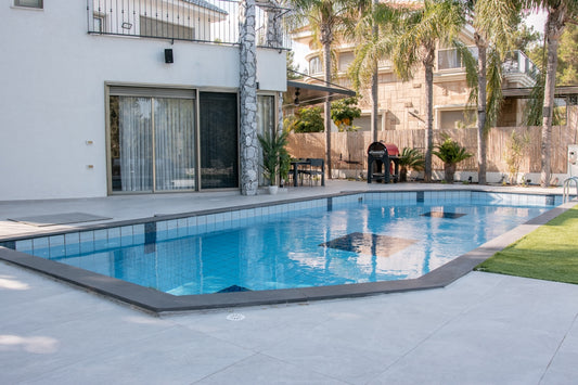 A modern house with a swimming pool and palm trees.